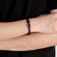 Bracelet jonc noir en acier inoxydable avec motif infini élégant pour homme.