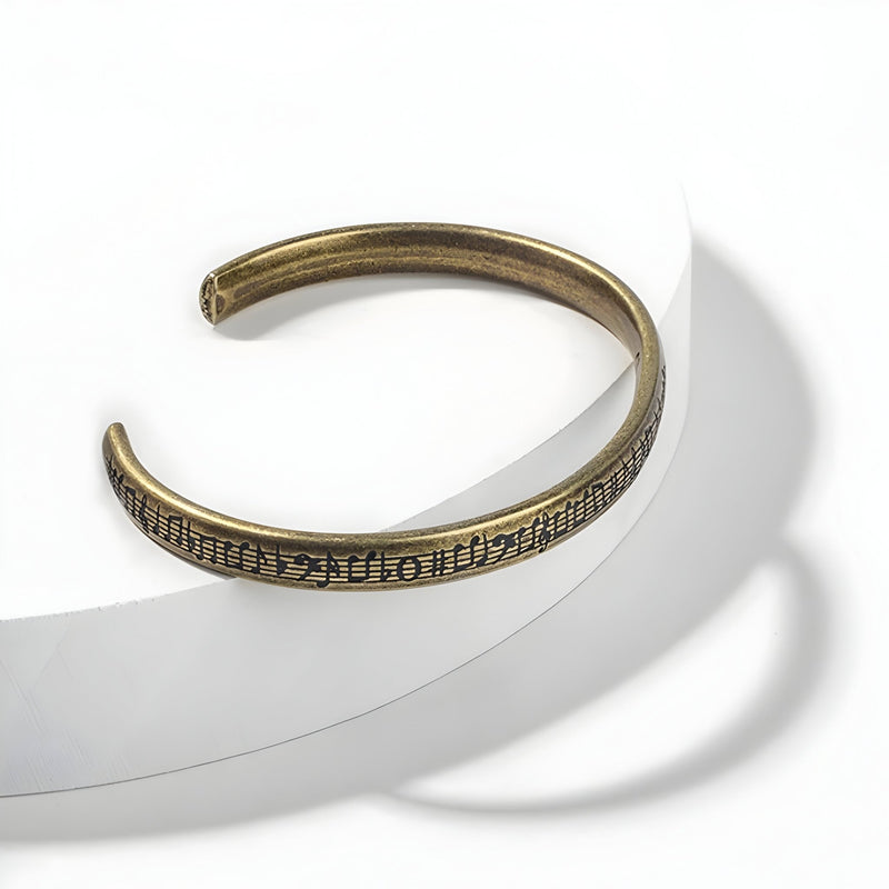 Bracelet jonc en acier inoxydable couleur bronze avec gravure de notes de musique, style mixte.