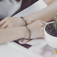 Bracelet jonc mixte en acier inoxydable argenté et doré, design lisse et minimaliste.