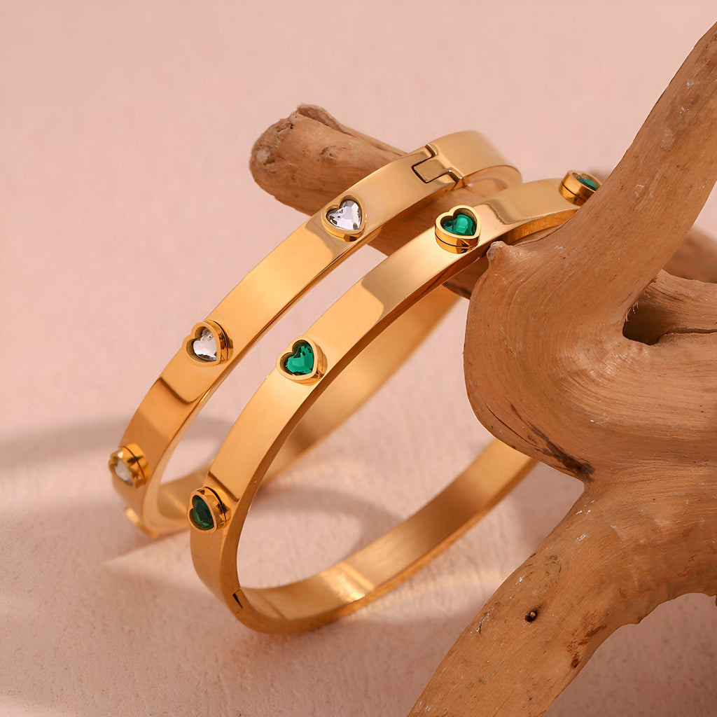 Bracelet jonc plaqué or 18 carats avec cœurs émaillés verts et pierres blanches scintillantes.