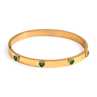 Bracelet jonc en acier plaqué or 18 carats avec cœurs verts sculptés et finition lisse.