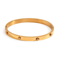 Bracelet jonc en acier inoxydable plaqué or 18 carats avec étoiles incrustées et finition lisse.