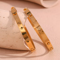 Bracelet jonc en acier inoxydable plaqué or 18 carats à étoiles, orné de pierres diamant et verte, modèle Katerina.