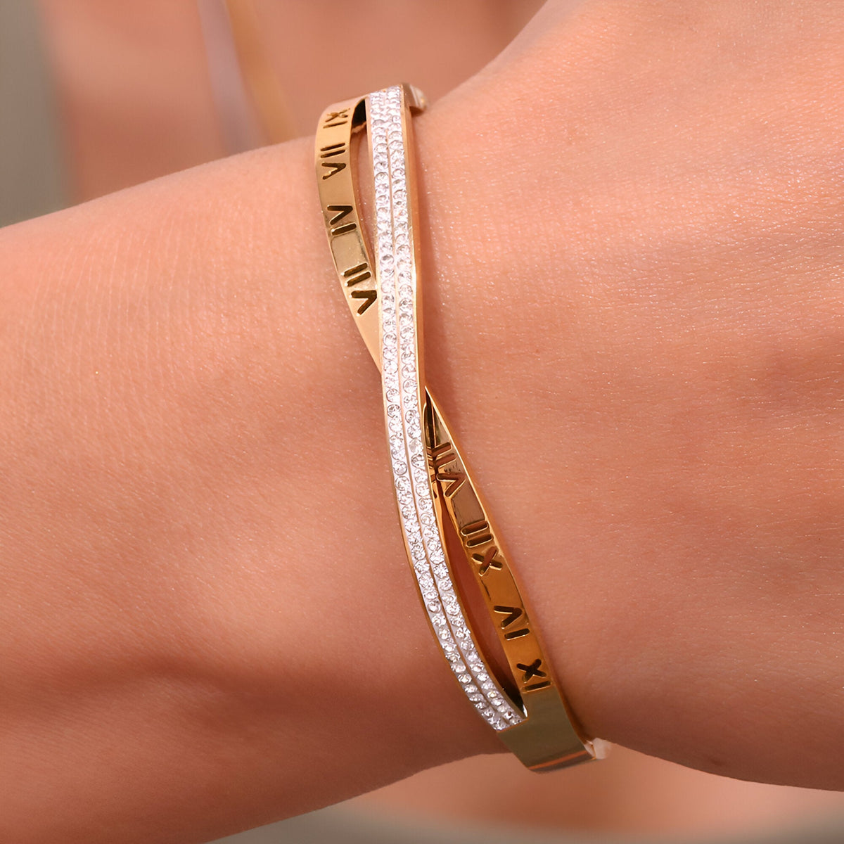 Bracelet jonc en acier doré 18 carats avec inscription chiffres romains et bracelet fin orné de petites pierres scintillantes.