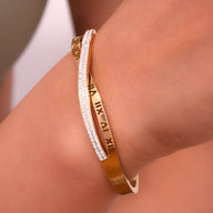 Bracelet jonc plaqué or 18 carats avec inscription chiffres romains et rangée de petits cristaux blancs.