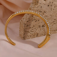 Bracelet jonc doré 18 carats avec rangée de zircons brillants, design élégant et minimaliste.