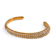 Bracelet jonc ouvert plaqué or 18 carats, orné de trois rangées de zircons scintillants.