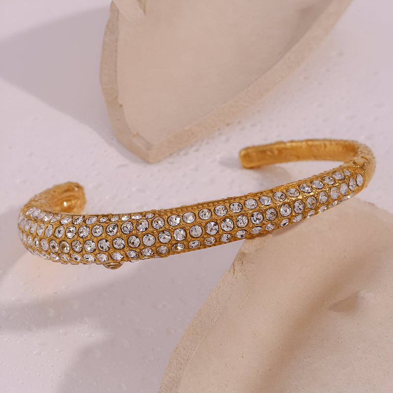 Bracelet jonc doré en acier inoxydable 18 carats, serti de multiples zircons scintillants.