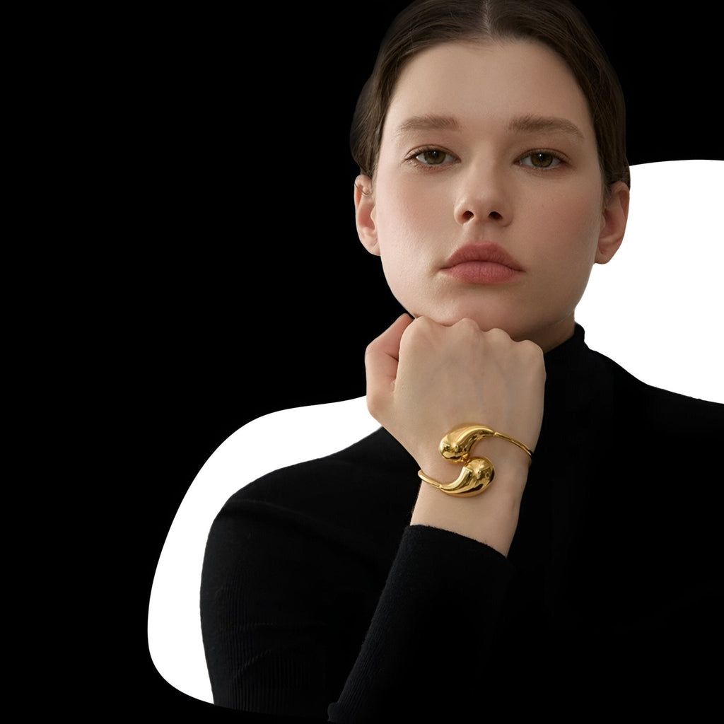 Bracelet jonc doré en acier inoxydable au design minimaliste et élégant porté au poignet féminin.