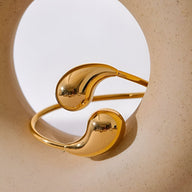 Bracelet jonc doré en acier inoxydable avec extrémités lisses et arrondies, style moderne et minimaliste.