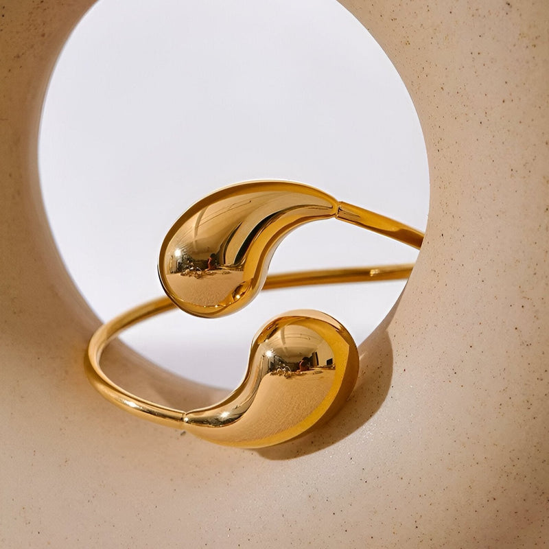 Bracelet jonc doré en acier inoxydable avec extrémités lisses et arrondies, style moderne et minimaliste.