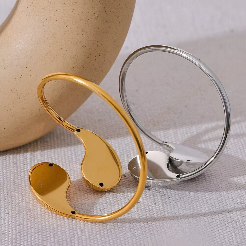 Bracelet jonc Ikayla en acier inoxydable, finition or brillant avec détail lisse et bords arrondis.