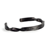 Bracelet jonc noir en acier inoxydable torsadé avec gravure "The Time is Now" pour homme.
