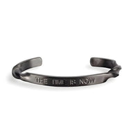 Bracelet jonc en acier inoxydable noir mat avec gravure "THE TIME IS NOW" pour homme.