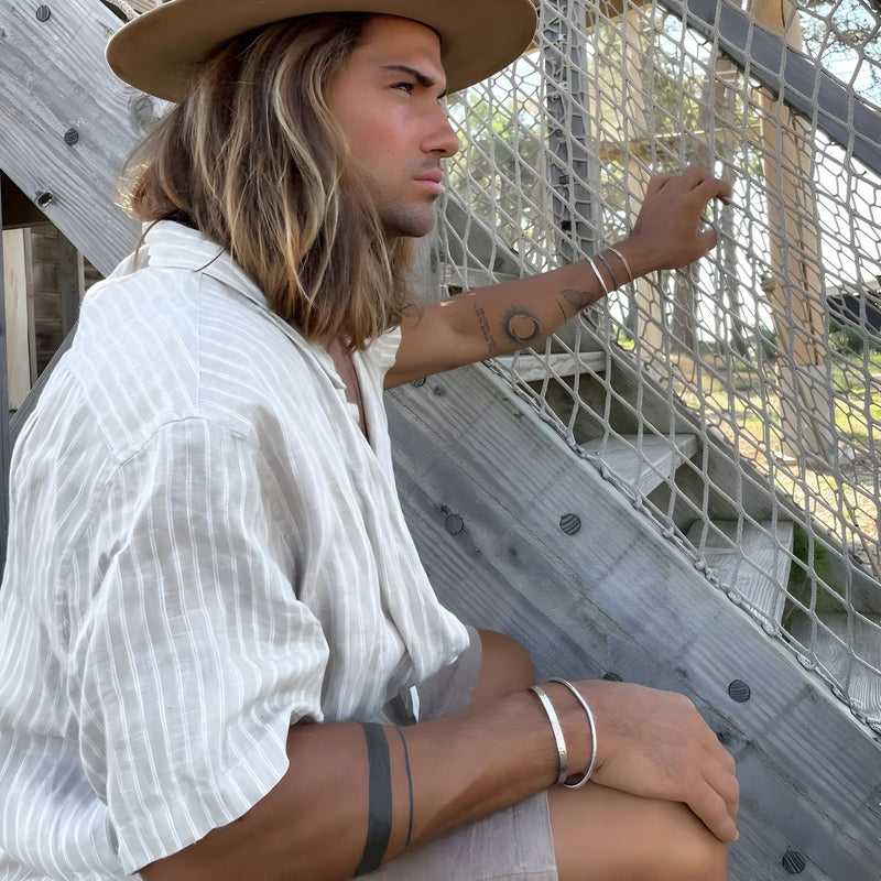 Bracelet jonc argenté en acier inoxydable, design lisse et épuré pour homme.