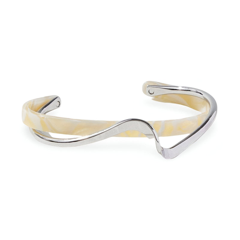 Bracelet jonc Denira en acrylique blanc tacheté avec détail en métal argenté fin et ondulé.