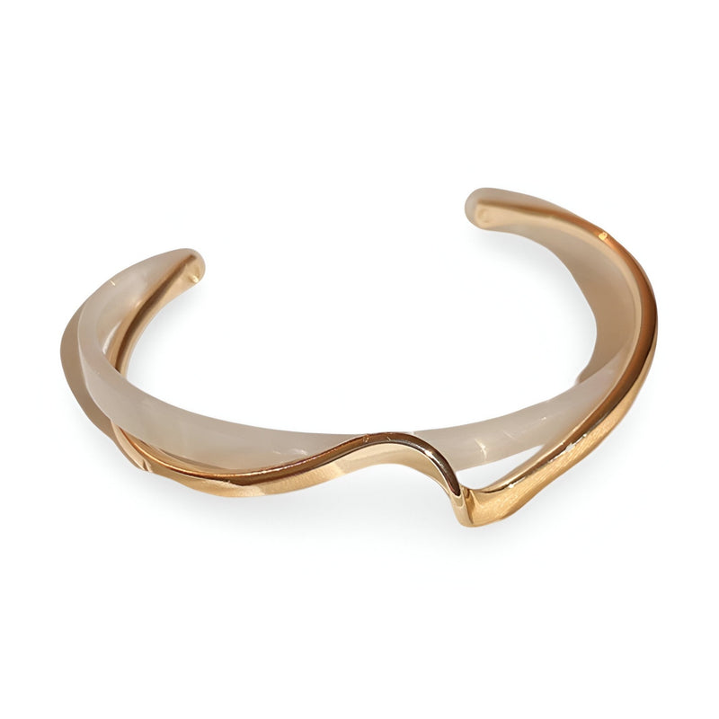 Bracelet jonc en acrylique marron avec détails en métal doré, forme ondulée élégante.