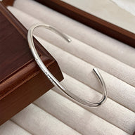 Bracelet jonc fin en argent sterling avec gravure "Smile", design épuré et moderne.