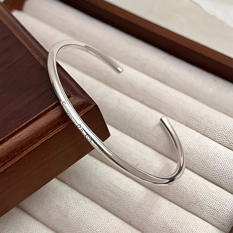 Bracelet jonc fin en argent sterling avec gravure "Smile", design épuré et moderne.