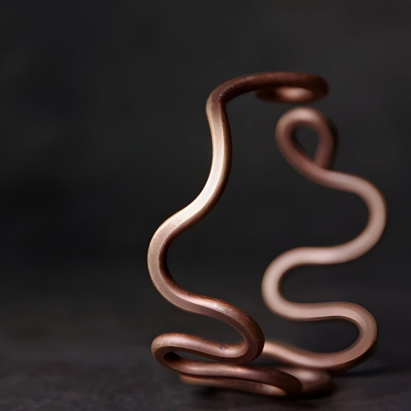 Bracelet jonc en cuivre à grande vague, finition lisse et brillante, design minimaliste et moderne.