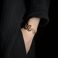 Bracelet jonc en cuivre marron avec motif grande vague porté sur poignet, style mixte, design Valter.