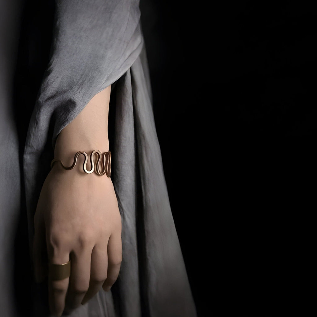 Bracelet jonc en cuivre marron à grande vague, design minimaliste et élégant, modèle Valter, porté sur poignet.
