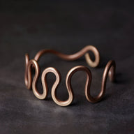 Bracelet jonc en cuivre couleur marron forme grande vague design ouvert élégant et moderne.