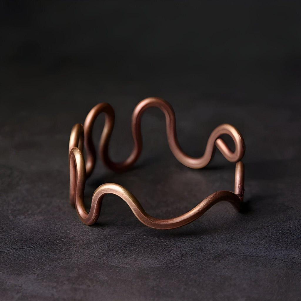 Bracelet jonc en cuivre à grande vague, finition mate, style minimaliste et moderne.