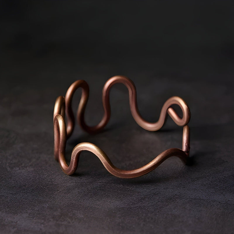 Bracelet jonc en cuivre à grande vague, finition mate, style minimaliste et moderne.