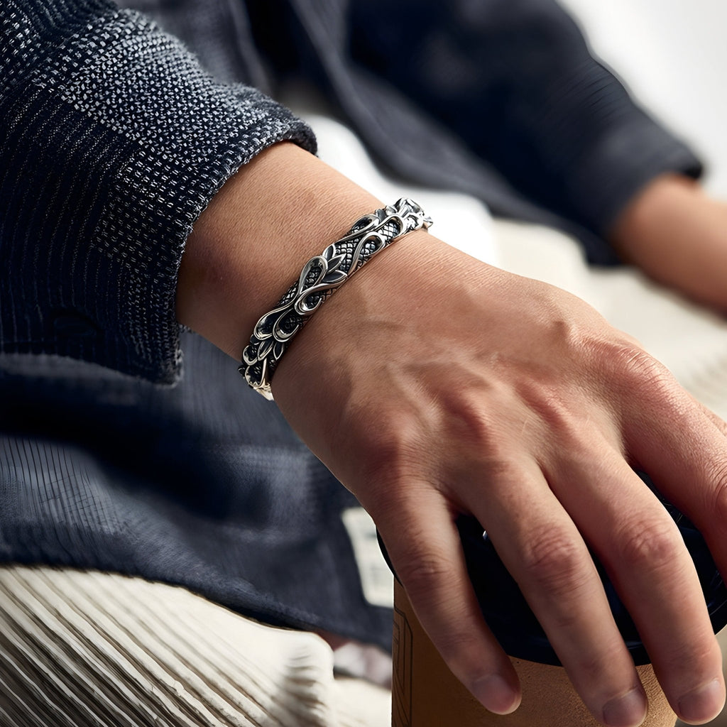 Bracelet jonc argenté en cuivre avec texture vagues porté au poignet masculin.