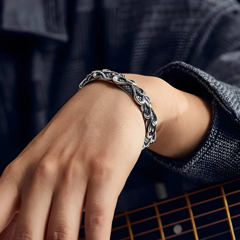 Bracelet jonc argenté avec motif vagues, style masculin, porté au poignet.