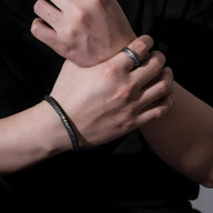 Bracelet jonc argenté avec motifs écailles de dragon masculin sur poignet et bague assortie en argent.