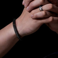 Bracelet jonc en cuivre argenté avec motif écailles de dragon texturé porté au poignet homme.