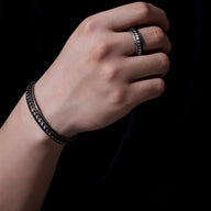 Bracelet jonc argenté en cuivre avec motif écailles de dragon porté au poignet homme.