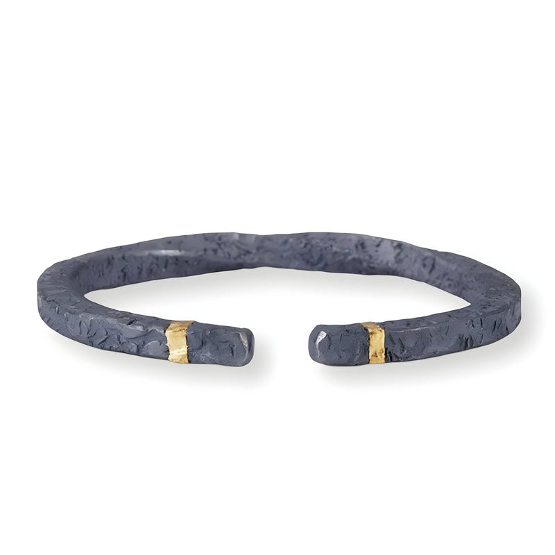 Bracelet jonc gris en cuivre texturé avec détails dorés aux extrémités, style rocheux pour homme.