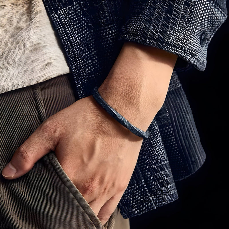 Bracelet jonc gris en cuivre plaqué argent et or avec texture rocheuse, porté homme.