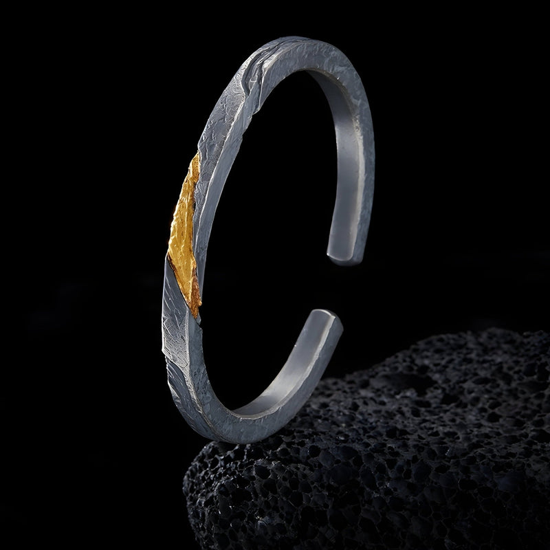 Bracelet jonc homme en cuivre gris avec plaque or, texture rocheuse sophistiquée.