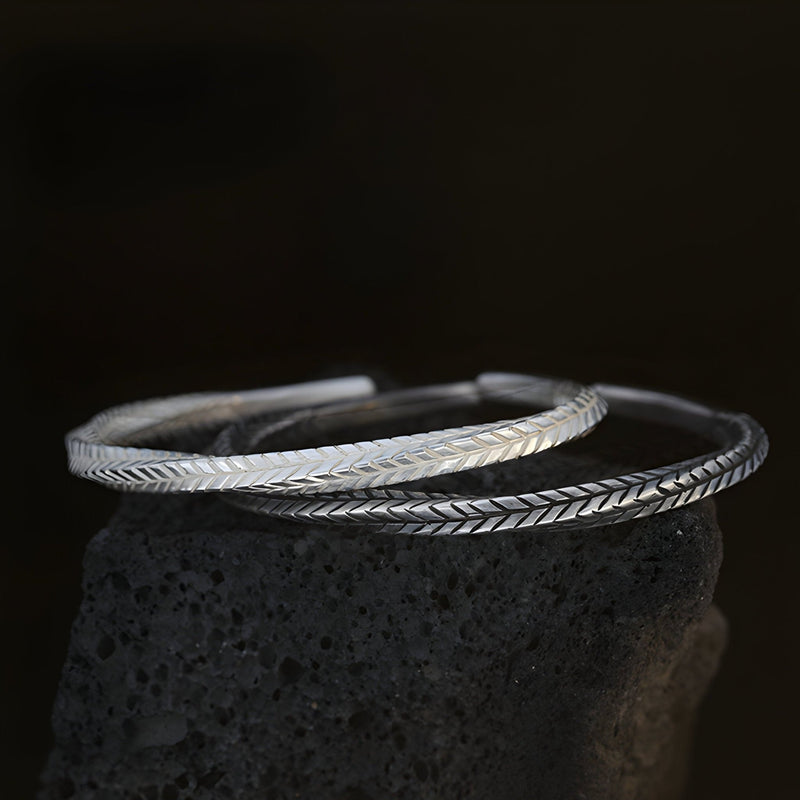 Bracelet jonc argenté en cuivre avec motifs flèche gravés, design élégant pour homme.