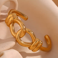 Bracelet jonc doré en acier inoxydable à motif de nœud d'agui élégant et poli.