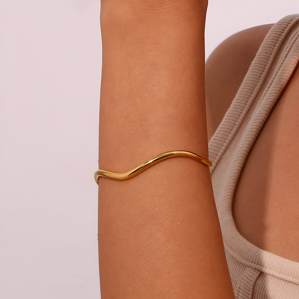 Bracelet jonc ondulé en acier inoxydable doré, design fin et élégant pour femme.