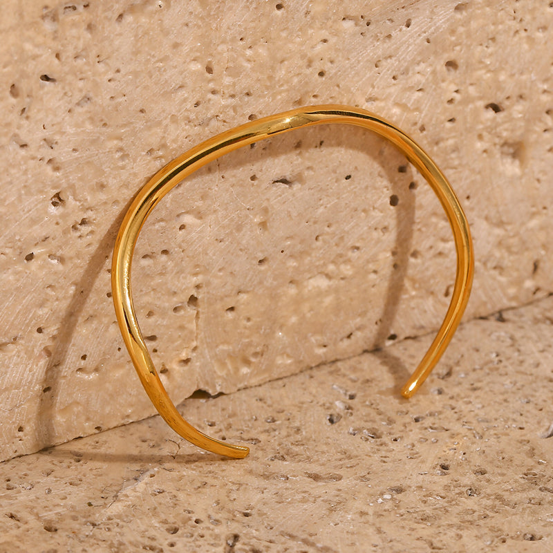 Bracelet jonc en acier inoxydable doré avec design ondulé moderne, modèle Lyra.