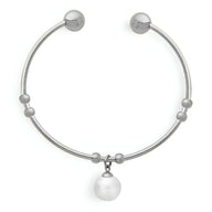 Bracelet jonc en titane argenté orné de petites perles et d’une perle blanche pendante.