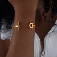 Bracelet jonc en titane plaqué or avec motifs géométriques cercle et barre.