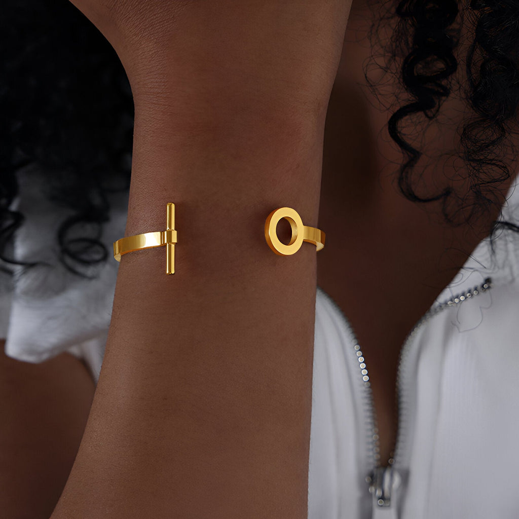 Bracelet jonc en titane plaqué or avec motifs géométriques cercle et barre.