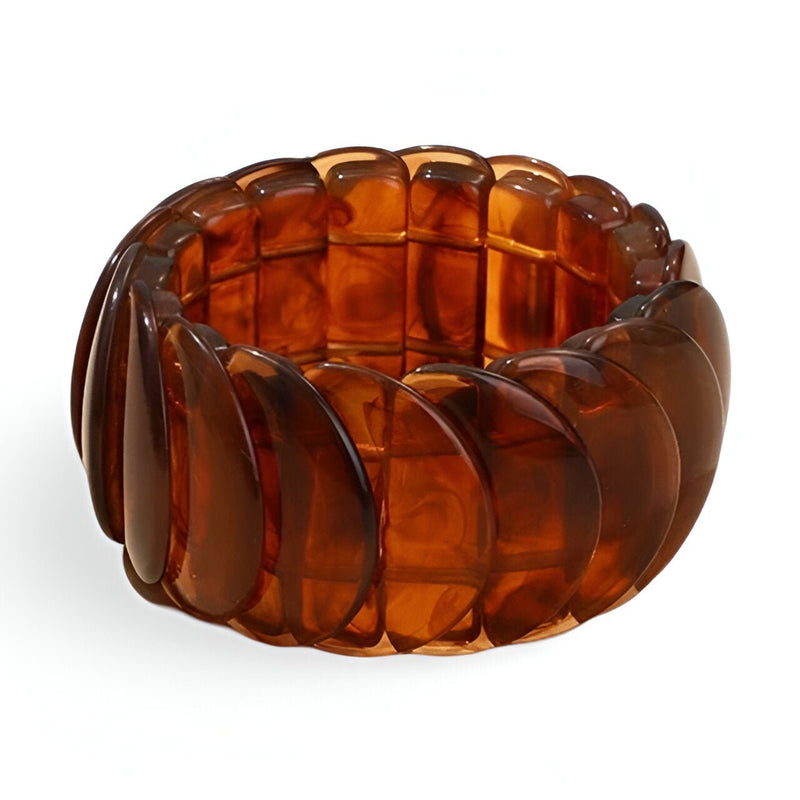Bracelet jonc épais en acrylique marron translucide à segments incurvés, style moderne et volumineux.