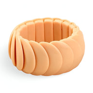 Bracelet jonc épais en acrylique beige pêche avec segments arrondis lisses et élastique invisible.