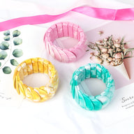 Lot de trois bracelets joncs épais en acrylique, couleurs jaune, rose et turquoise en dégradé marbré.