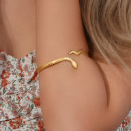 Bracelet jonc doré esprit serpent en acier inoxydable avec texture serpent et extrémités arrondies.