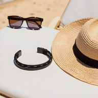 Bracelet jonc noir en acier inoxydable avec cordon en coton, design épuré pour homme.