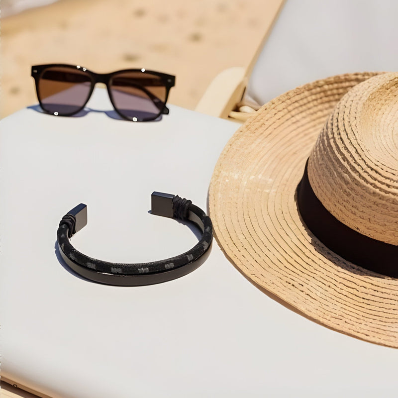 Bracelet jonc noir en acier inoxydable avec cordon en coton, design épuré pour homme.